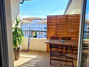 - un balcon avec une table et des chaises en bois dans l'établissement Proche Stade Toulousain - Blagnac - Parking, à Toulouse