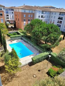 - une vue sur la piscine en face d'un bâtiment dans l'établissement Proche Stade Toulousain - Blagnac - Parking, à Toulouse
