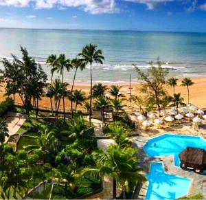 uma vista para a praia a partir da varanda de um resort em flat apt mobiliado beira mar no Recife