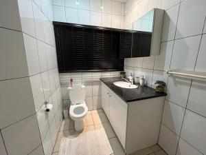 a white bathroom with a toilet and a sink at 337 Justice Mahomed Guest House in Pretoria +32 photos