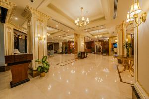 een grote lobby met een grote marmeren vloer en een kroonluchter bij Braira Al Jubail in Al Jubail