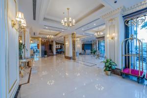 een lobby met een grote witte marmeren vloer en een kroonluchter bij Braira Al Jubail in Al Jubail