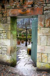 uma entrada para um edifício de pedra com uma porta verde em Gardener's Cottage em Lancaster