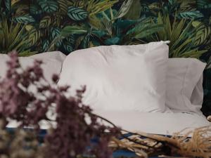 uma almofada branca numa cama com papel de parede floral em Apartamentos Abadía. em Corella