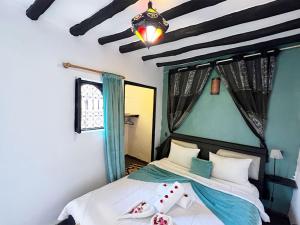 a bedroom with a bed with two pillows on it at Riad Lazord De Marrakech Entier in Marrakesh