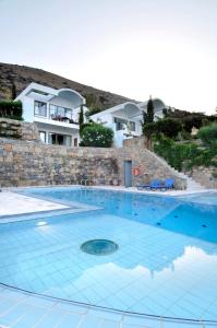 a large swimming pool in front of a house at Elounda Living Residences in Elounda