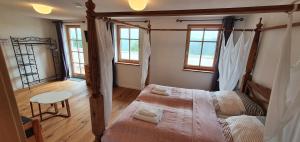 una camera con due letti in una stanza con finestre di Lana Salta Alpakas - Gemütliche Gästezimmer auf dem Bauernhof a Murrhardt