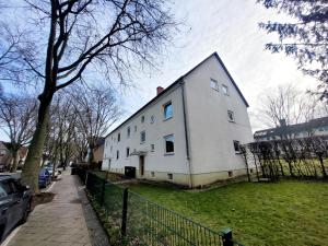uma casa branca numa rua com uma cerca em Get-your-flat - traumhaft niedliche FeWo 2 Zr Kü Bad, Haustier auf Anfrage, ruhig & stadtnah EG - TOP em Bochum