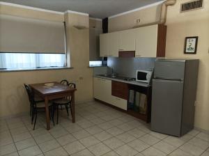 a small kitchen with a table and a refrigerator at Residence Le Arcate in Gavirate