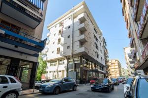 una concurrida calle de la ciudad con coches aparcados frente a un edificio en Hotel Palace en Battipaglia