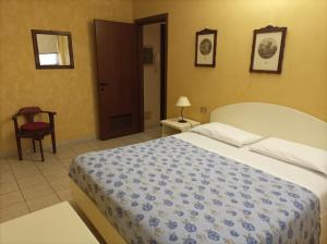 a bedroom with a large bed and a chair at Residence Le Arcate in Gavirate