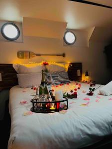 a bed with a tray with flowers and candles on it at La cabine du Marinier in Toulouse