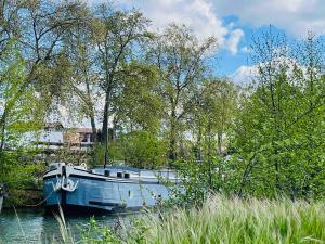 a blue boat is docked in the water at La cabine du Marinier in Toulouse