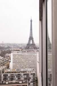 a view of the eiffel tower from a window at Veeve - Eiffel Skies in Paris