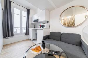 uma sala de estar com um sofá e uma mesa de vidro em Studio mezzanine proche Zenith - Paris 19 - 2P em Paris