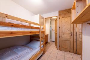 a bedroom with two bunk beds and a bathroom at Le Chemin des Alpages - Vue montagne in La Giettaz