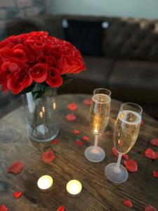 Um vaso de rosas vermelhas e duas taças de champanhe. em Just'un Instant em Landrecies