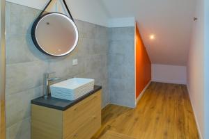 La salle de bains est pourvue d'un lavabo et d'un miroir. dans l'établissement L’Innamoramento - Charmant appt pour 4, à Solesmes