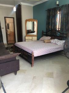 una camera con un letto e un grande specchio di Ayub House a Karachi