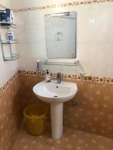 baño con lavabo, espejo y cubo en Ayub House en Karachi
