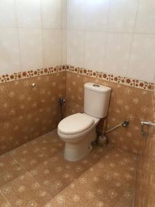 a bathroom with a white toilet in a room at Ayub House in Karachi
