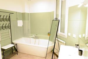 a bathroom with a tub and a sink at Pomerol au Cœur in Pomerol