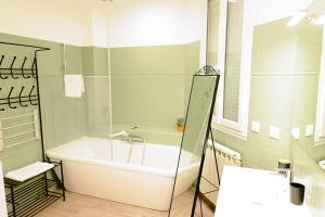 a bathroom with a tub and a sink at Pomerol au Cœur in Pomerol +21 photos