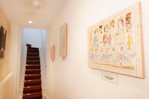 a hallway with a painting on the wall and a staircase at Grande maison en pierre à Pomerol - 3 chambres, parking, proche Saint-Emilion in Pomerol