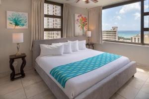 um quarto com uma cama e vista para o oceano em Newly Remodeled Corner Unit at the Waikiki Banyan with Diamond Head Views condo em Honolulu