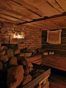 una habitación con una pared de piedra y una habitación con rocas en Viesu Nams “Noras” en Ķesterciems