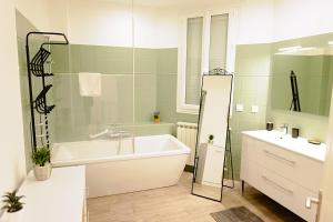 a bathroom with a bath tub and a sink at Grande maison en pierre à Pomerol - 3 chambres, parking, proche Saint-Emilion in Pomerol
