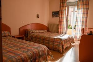 a hotel room with two beds and a window at Central Hôtel in Cerbère