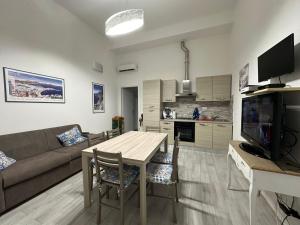 a living room with a couch and a table with chairs at Via Serri 7/A in Follonica