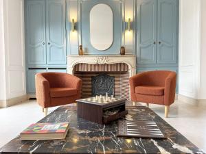 a living room with two chairs and a fireplace at La Meslaysienne - Comfortable house, swimming pool in Meslay-le-Vidame +65 photos