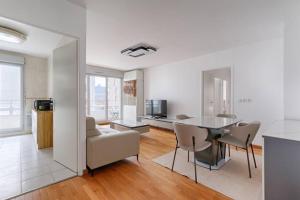 una sala de estar blanca con mesa y sillas en Saint Denis/Leon Nozal : Magnifique Apartment 5P en Saint-Denis