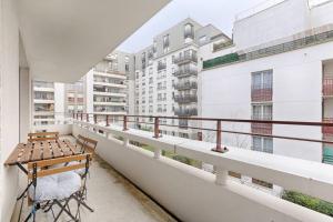 - Balcón con mesa de madera y sillas en un edificio en Saint Denis/Leon Nozal : Magnifique Apartment 5P en Saint-Denis