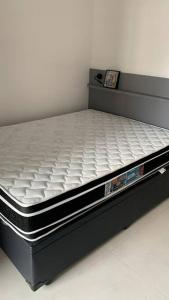 a bed with a black frame and white mattress at Studio Metrô Brooklin in Sao Paulo