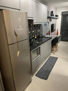 a kitchen with a large stainless steel refrigerator at Studio Metrô Brooklin in Sao Paulo