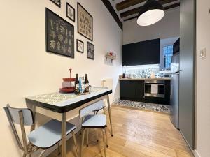 a kitchen with a table and chairs and a refrigerator at Le jardinet de la cathédrale in Chartres