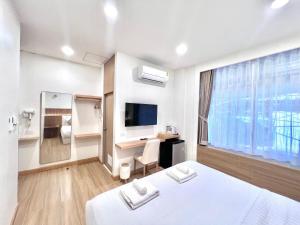Habitación de hotel con cama y escritorio en Mitaree Hotel 1, en Mae Sariang