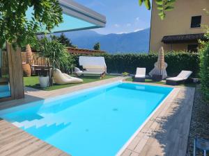 a blue swimming pool next to a house at villa relax in Riva del Garda