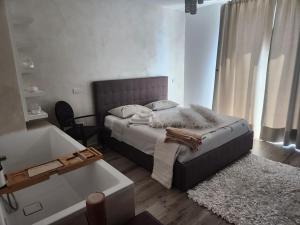 villa relax في ريفا ديل غاردا: غرفة نوم مع سرير وحوض استحمام