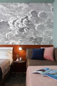 a bedroom with two beds and a painting of clouds at Hotel Tremoggia in Chiesa in Valmalenco