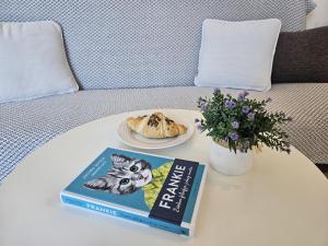 a book and a plate of food on a table at Apartments Vjera Rukavac in Rukavac