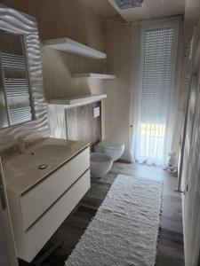 villa relax في ريفا ديل غاردا: حمام ابيض مع مرحاض ومغسلة