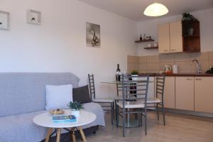 a living room with a table and chairs and a kitchen at Apartments Vjera Rukavac in Rukavac