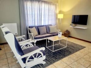 uma sala de estar com um sofá, cadeiras e uma mesa em Summerville Place em Addo