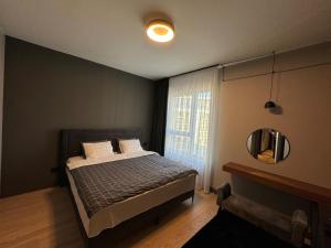 Un dormitorio con una cama con espejo y una ventana. en Belgrade Waterfront Luxury Apartment, en Belgrado