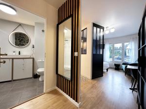 ein Badezimmer mit einem WC, einem Waschbecken und einem Spiegel in der Unterkunft C le 15 - Studio Cosy avec Parking in Chartres