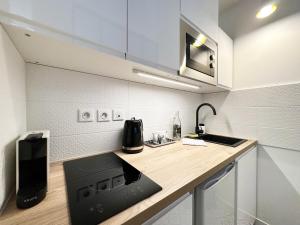 a kitchen with a counter with a sink and a stove at C le 15 - Studio Cosy avec Parking in Chartres